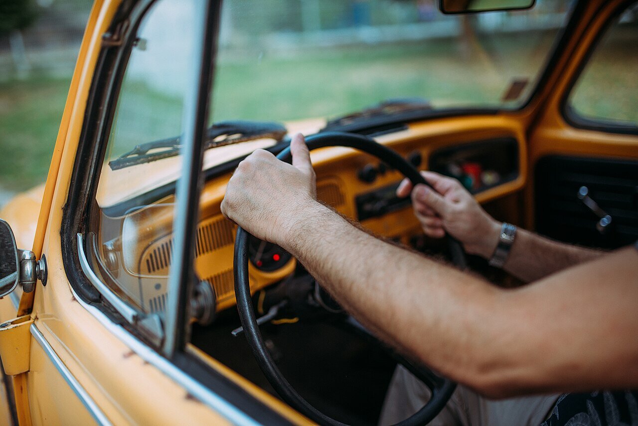 Student holding steering wheel during driving lesson